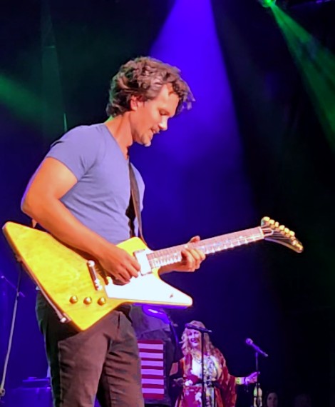 Tom playing a Gibson Explorer on stage